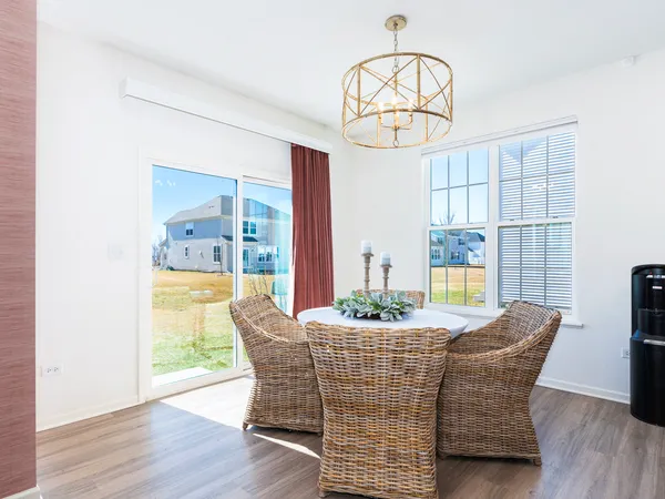 a dining room with furniture a chandelier and wooden floor
