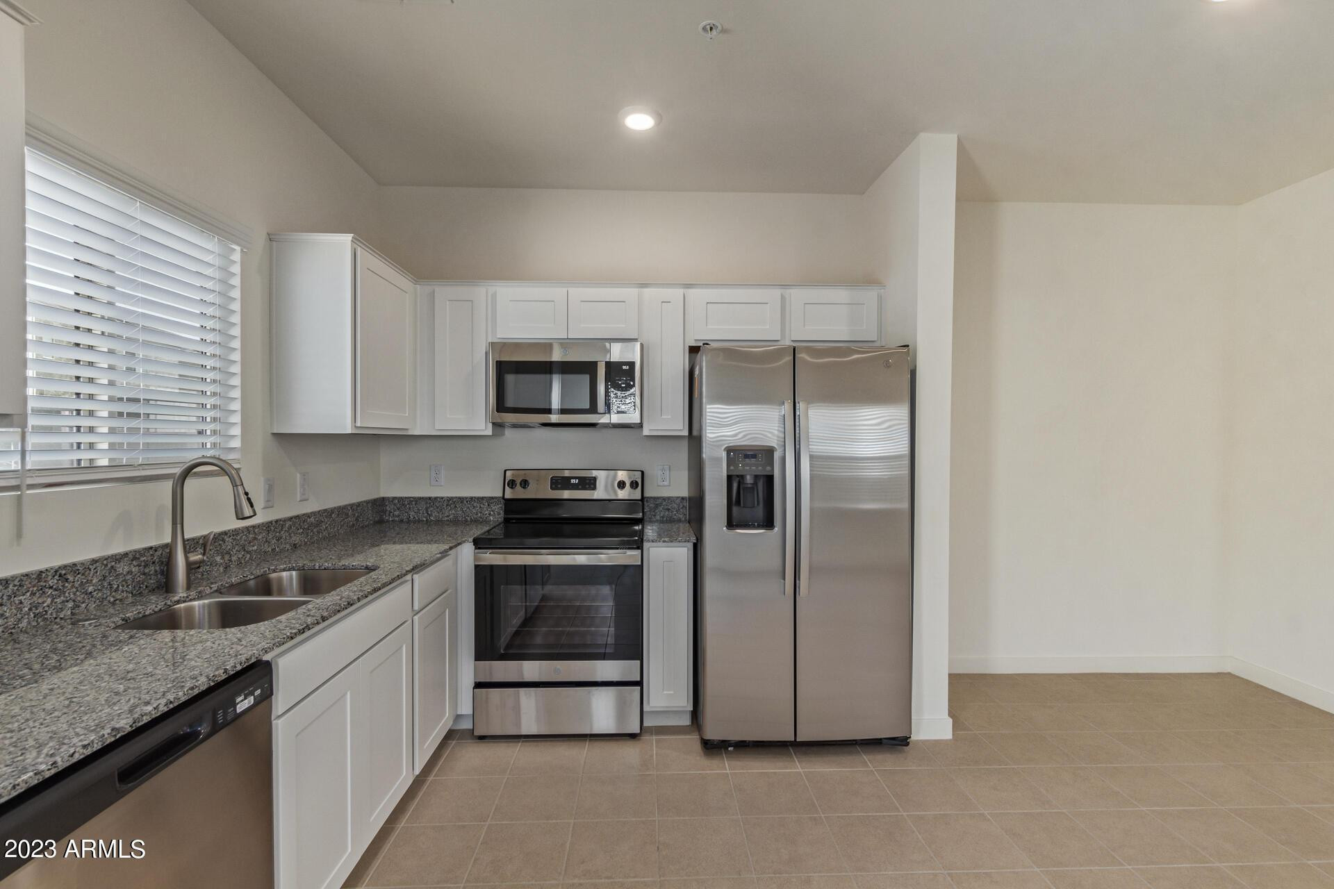 2280 West Laurie Lane Phoenix, AZ 85021 - Photo 7 of 27 a kitchen with stainless steel appliances granite countertop a sink stove and refrigerator