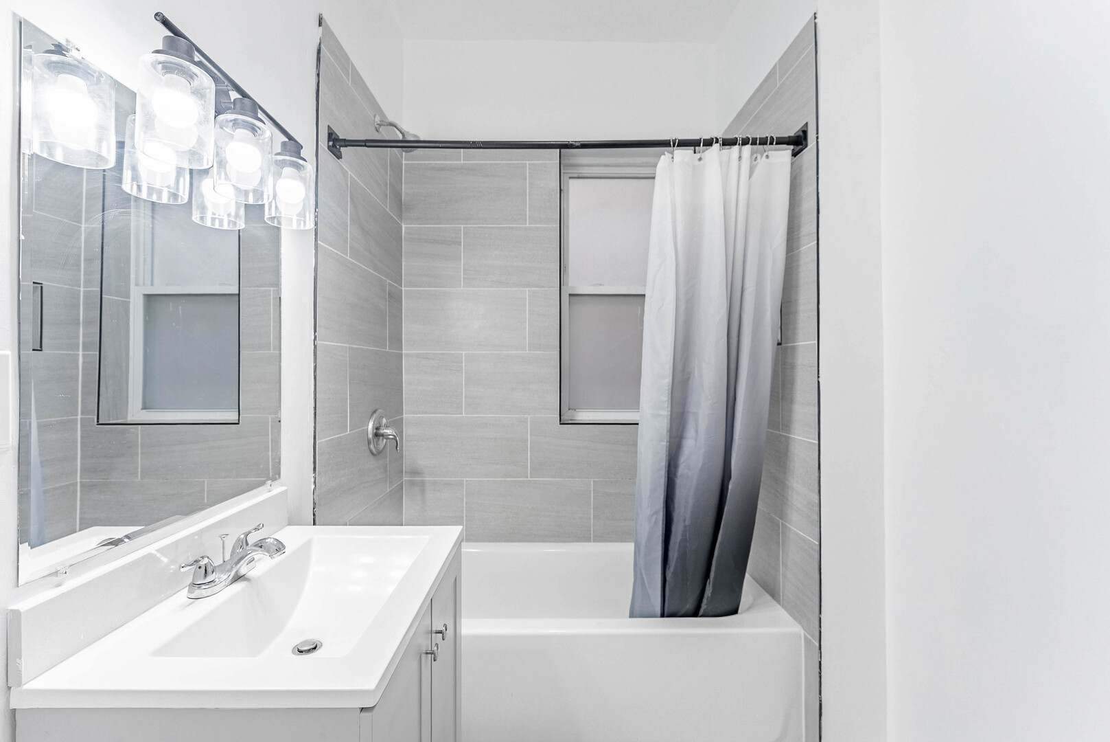 4200 West 21st Place, Unit 2F Chicago, IL 60623 - Photo 14 of 19 a bathroom with a sink a mirror a bathtub and shower