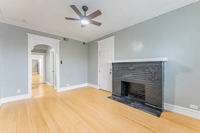 a view of empty room with wooden floor and fireplace