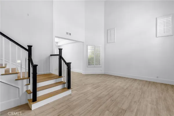 a view of a room with wooden floor and entryway