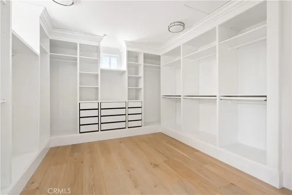 a view of walk in closet with empty racks