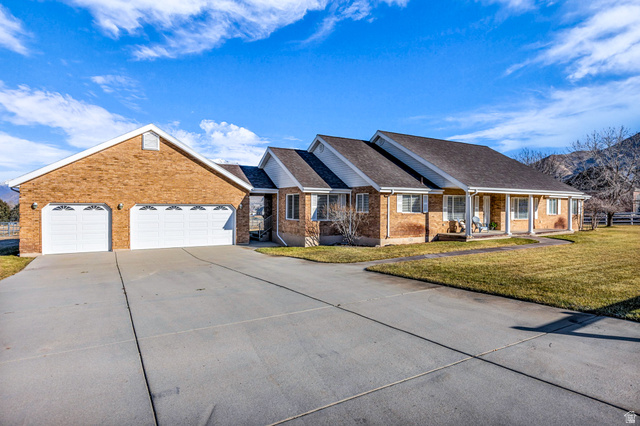 1060 West 2620th Street South Mapleton, UT 84664 - Photo 83 of 87 Ranch-style house featuring a front lawn, concrete driveway, a garage, covered porch, and brick siding
