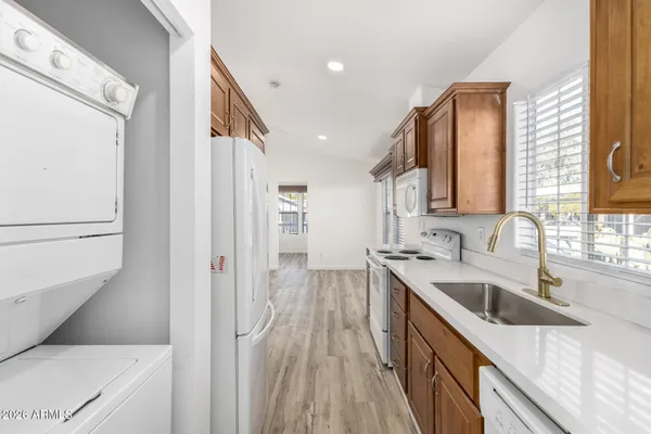 a kitchen with a sink a counter top space stainless steel appliances cabinets and a large window