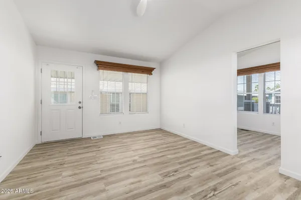 an empty room with wooden floor and windows