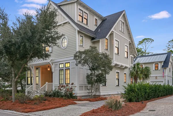 a view of a house with potted plants and a bench