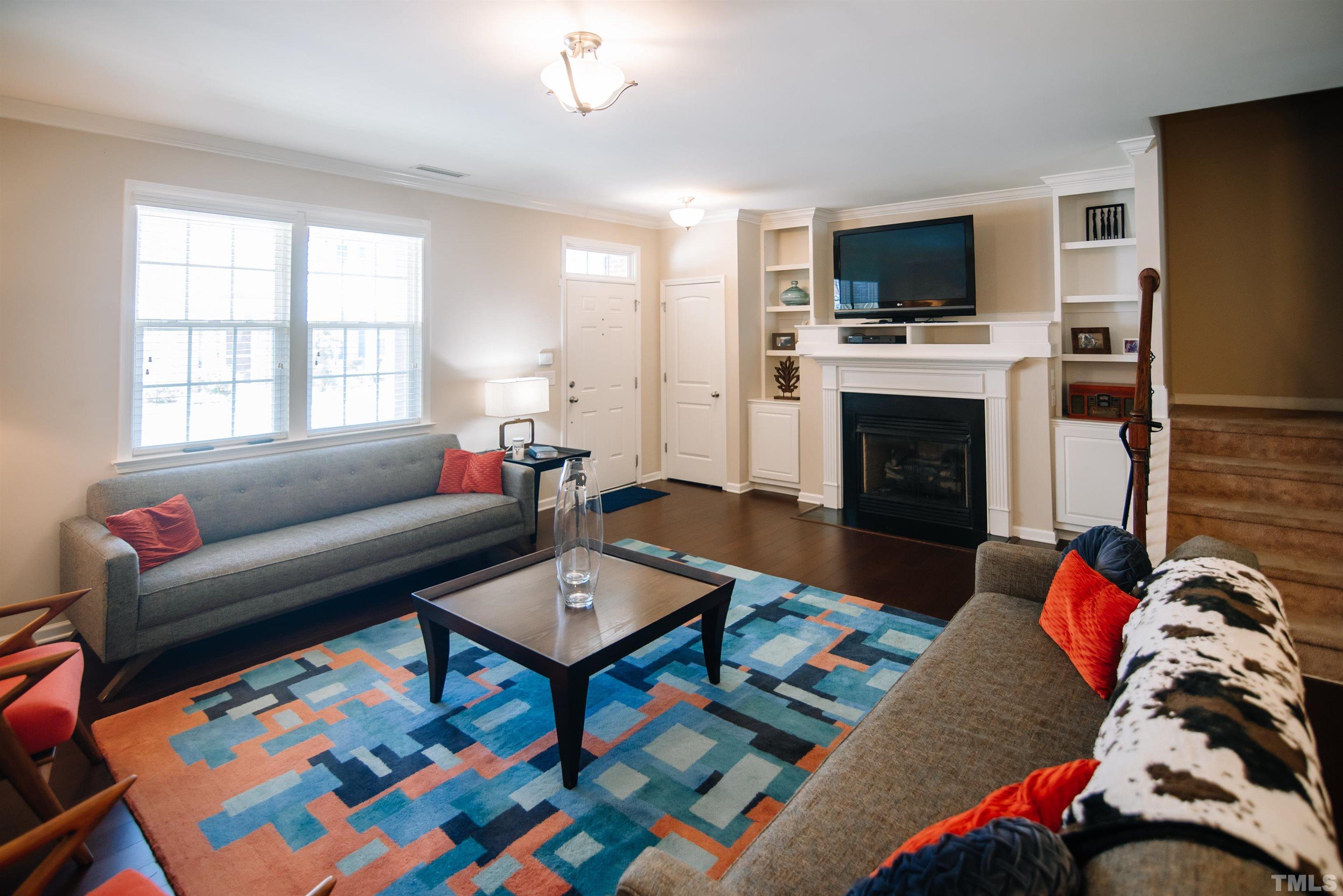 1308 Still Monument Way Raleigh, NC 27603 - Photo 3 of 21 a living room with furniture a flat screen tv and a fireplace