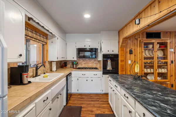 a large kitchen with stainless steel appliances granite countertop a stove refrigerator and cabinets
