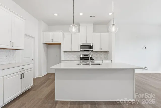 a kitchen with kitchen island a sink stainless steel appliances and cabinets