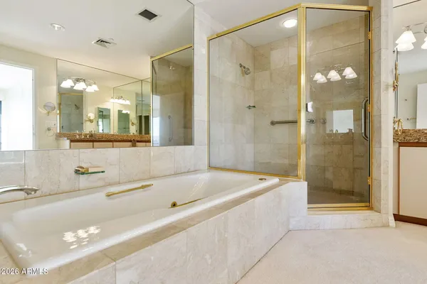 a bathroom with a granite countertop sink a mirror and a bathtub