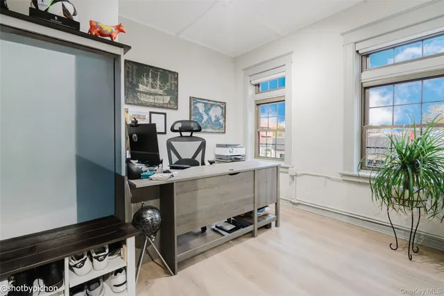 a view of a hallway with a glass door and furniture