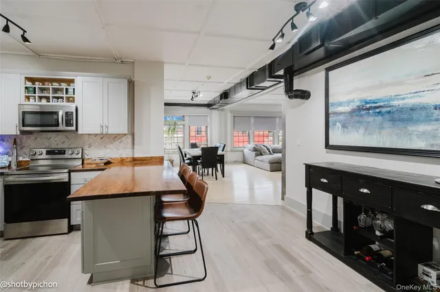 a kitchen with stainless steel appliances granite countertop a stove a sink dishwasher and a refrigerator with wooden floor