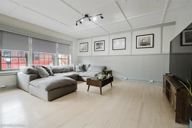 a living room with furniture a flat screen tv and a window