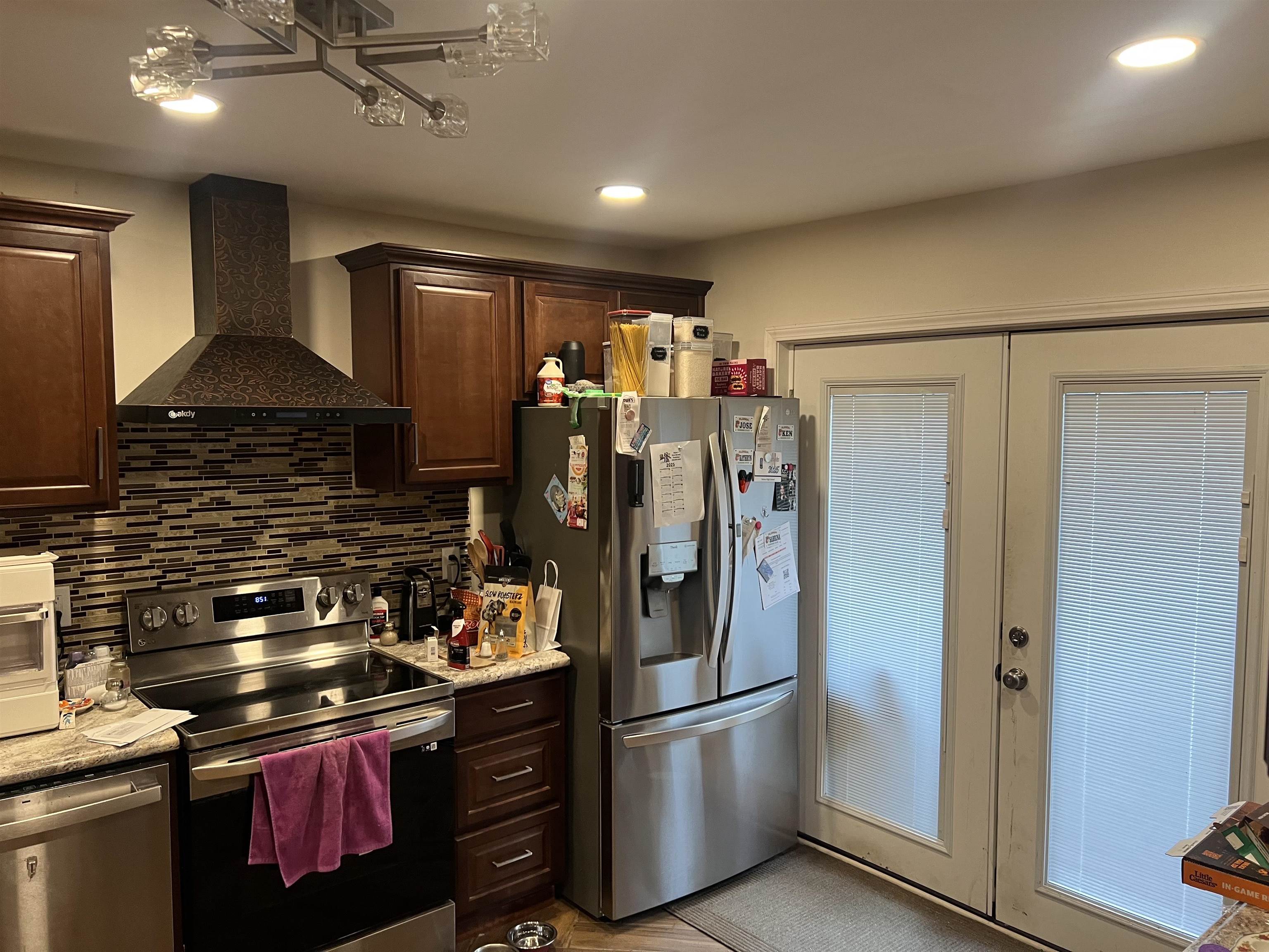 6758 Racquet Club Drive, Unit 6758 Memphis, TN 38119 - Photo 2 of 7 a kitchen with stainless steel appliances granite countertop a refrigerator a stove and a sink with wooden floor