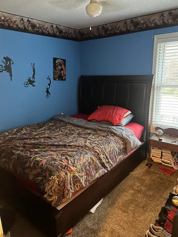 a bed sitting in a bedroom next to a window