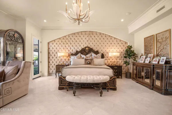 a spacious bedroom with a bed a couch and large window