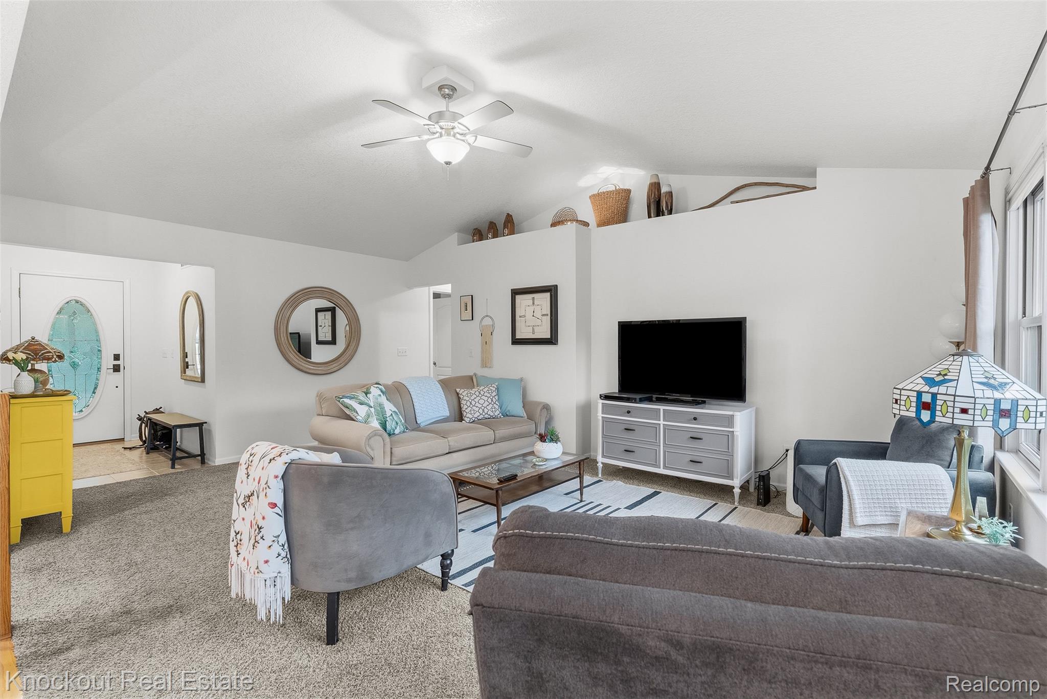 8436 Birch Run Road Millington, MI 48746 - Photo 9 of 44 Vaulted ceiling living area featuring a ceiling fan, carpet flooring, and an elevated display shelf