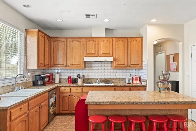 a kitchen with large windows sink and cabinets