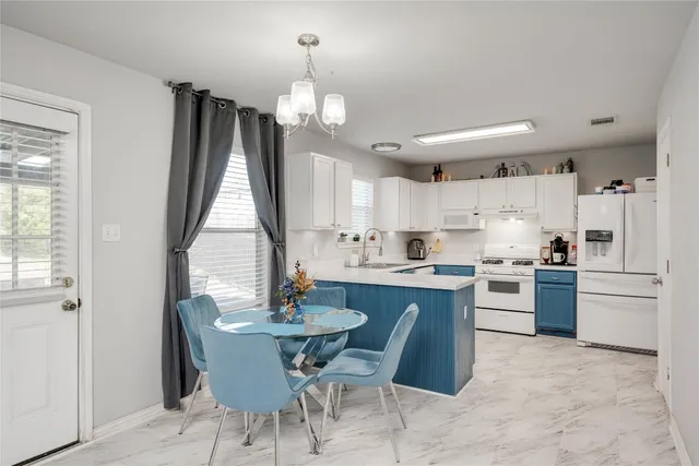 a kitchen with kitchen island granite countertop a sink cabinets and stainless steel appliances