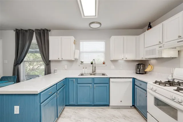 a kitchen with a sink cabinets appliances and a window