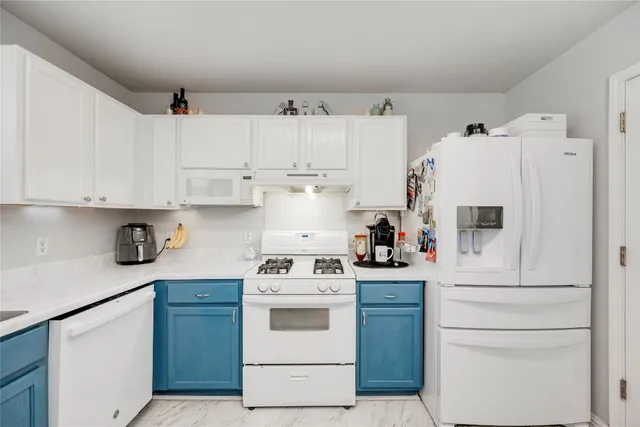 a kitchen with cabinets appliances and wooden floor