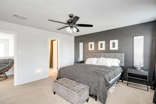 a spacious bedroom with a large bed and a chandelier