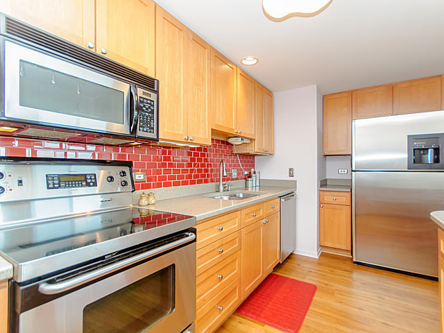 61 West 15th Street, Unit 607 Chicago, IL 60605 - Photo 3 of 23 a kitchen with stainless steel appliances granite countertop a stove a sink and a microwave