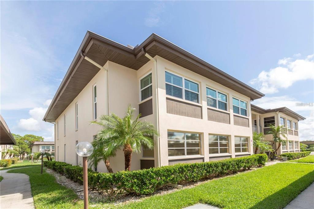 4557 Garnet Drive, Unit 102 New Port Richey, FL 34652 - Photo 2 of 14 a front view of a house with a yard