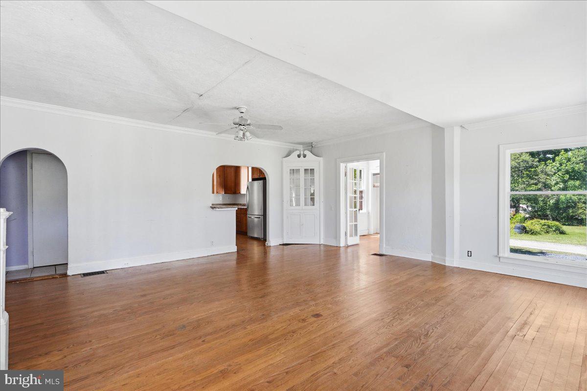 73 Church Road Arnold, MD 21012 - Photo 6 of 29 a view of an empty room with wooden floor and a window