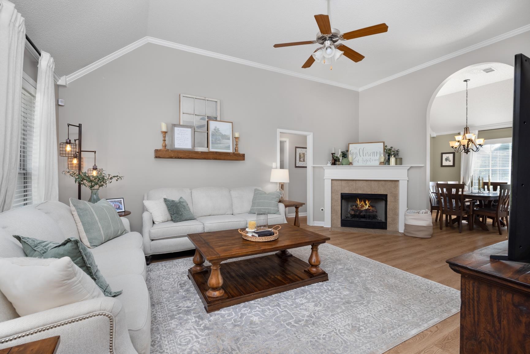 505 Terry Road Oakland, TN 38060 - Photo 7 of 40 Living room featuring wood finished floors, ornamental molding, lofted ceiling, a ceiling fan, and a tiled fireplace