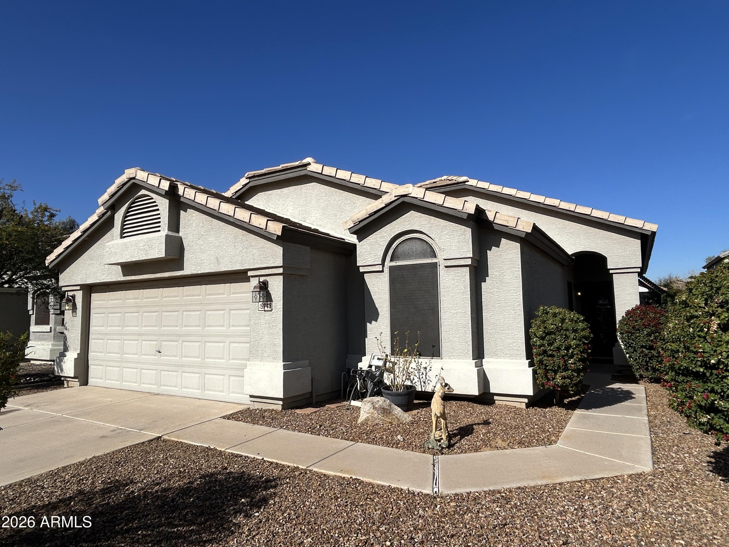 15948 West Latham Street Goodyear, AZ 85338 - Photo 1 of 14 a front view of a house with garden