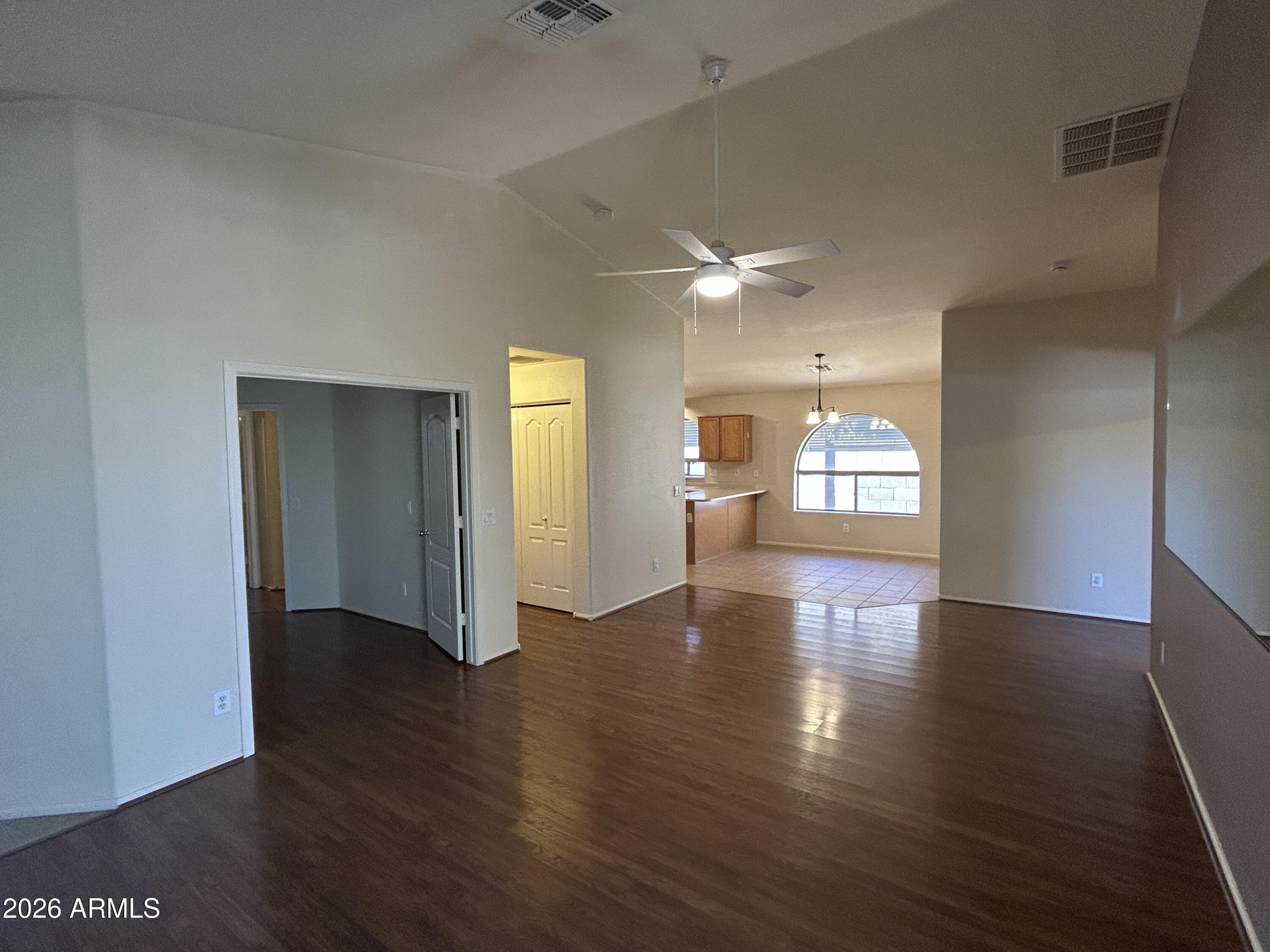 15948 West Latham Street Goodyear, AZ 85338 - Photo 5 of 14 a view of an empty room with window and wooden floor
