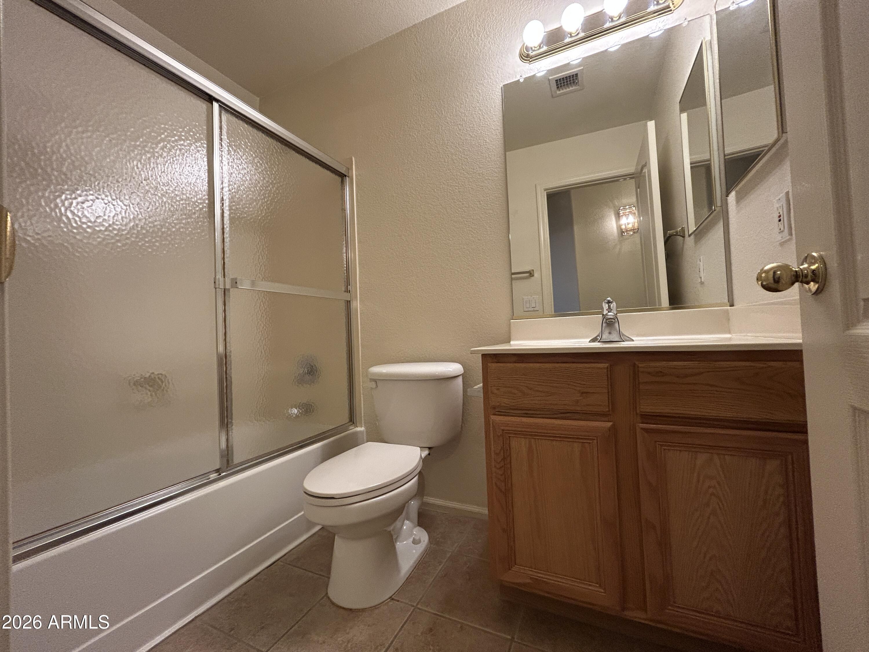15948 West Latham Street Goodyear, AZ 85338 - Photo 9 of 14 a bathroom with a sink a toilet and shower