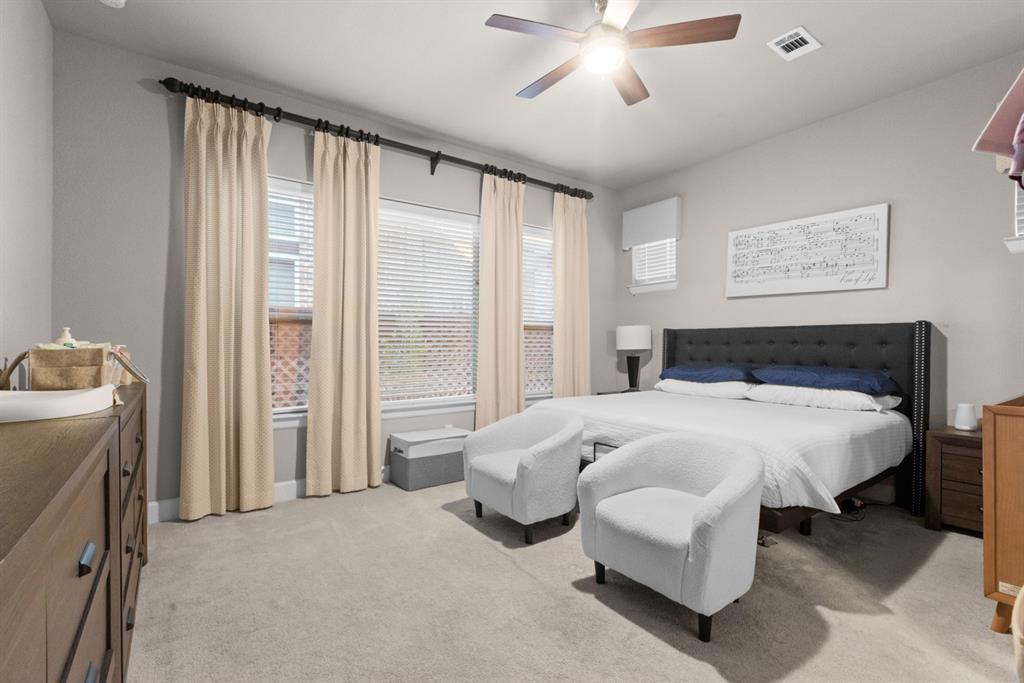 5417 Harbour Road Richardson, TX 75082 - Photo 17 of 23 a spacious bedroom with a bed and a chandelier