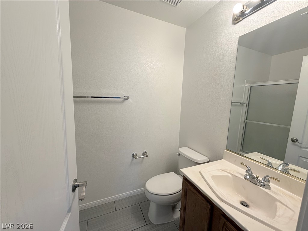 6116 Rabbit Track Street Las Vegas, NV 89130 - Photo 19 of 28 A well-appointed bathroom features a practical vanity with an integrated sink and bright lighting.
