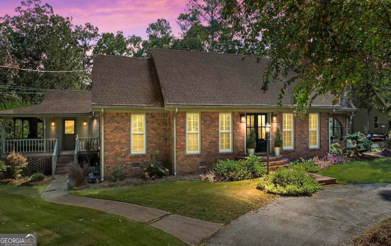 a front view of a house with a yard garden and outdoor seating