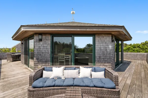 a view of a roof deck with couches and potted plants