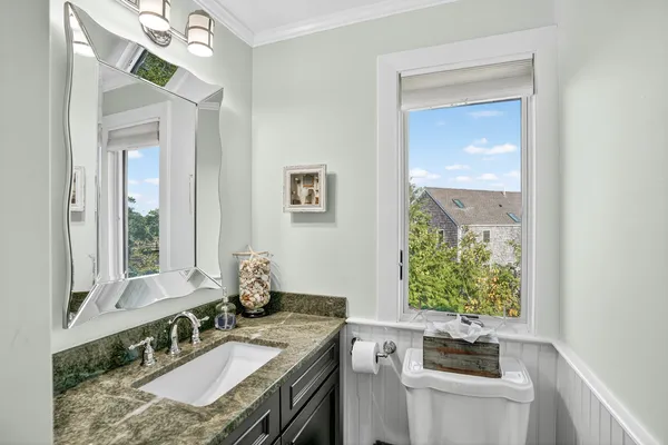 a bathroom with a granite countertop sink a toilet and a mirror
