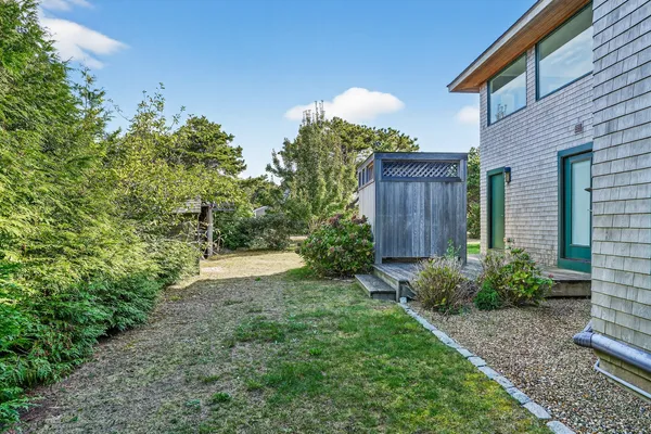 a view of a backyard with potted plants and wooden fence
