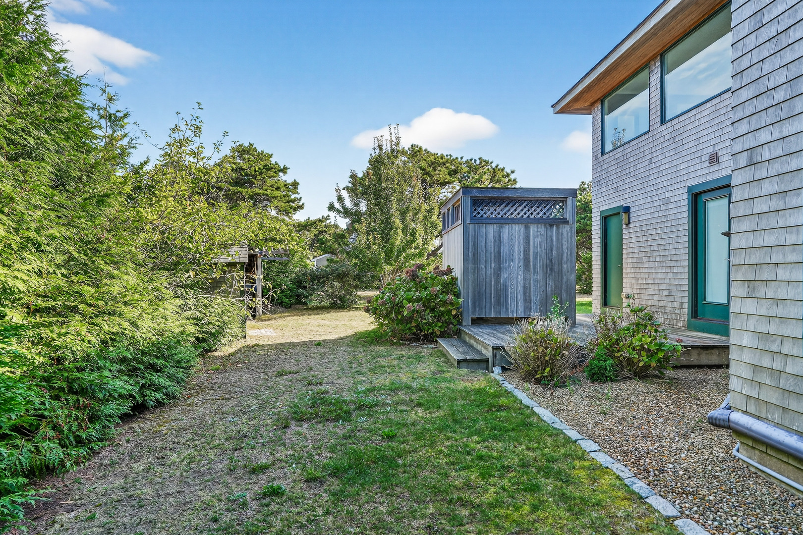 76 Washque Avenue Edgartown, MA 02539 - Photo 45 of 50 a view of a backyard with potted plants and wooden fence