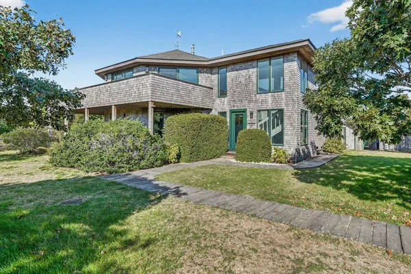 a front view of a house with yard and green space
