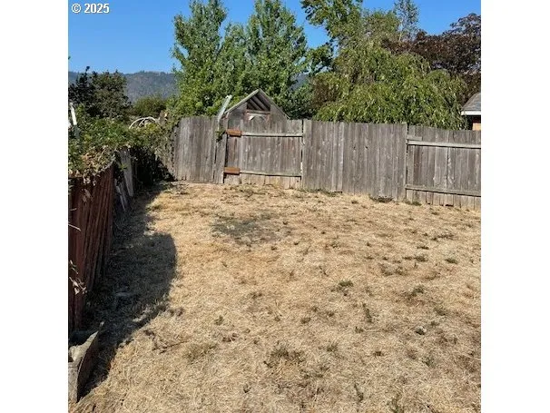 a view of a yard with wooden fence