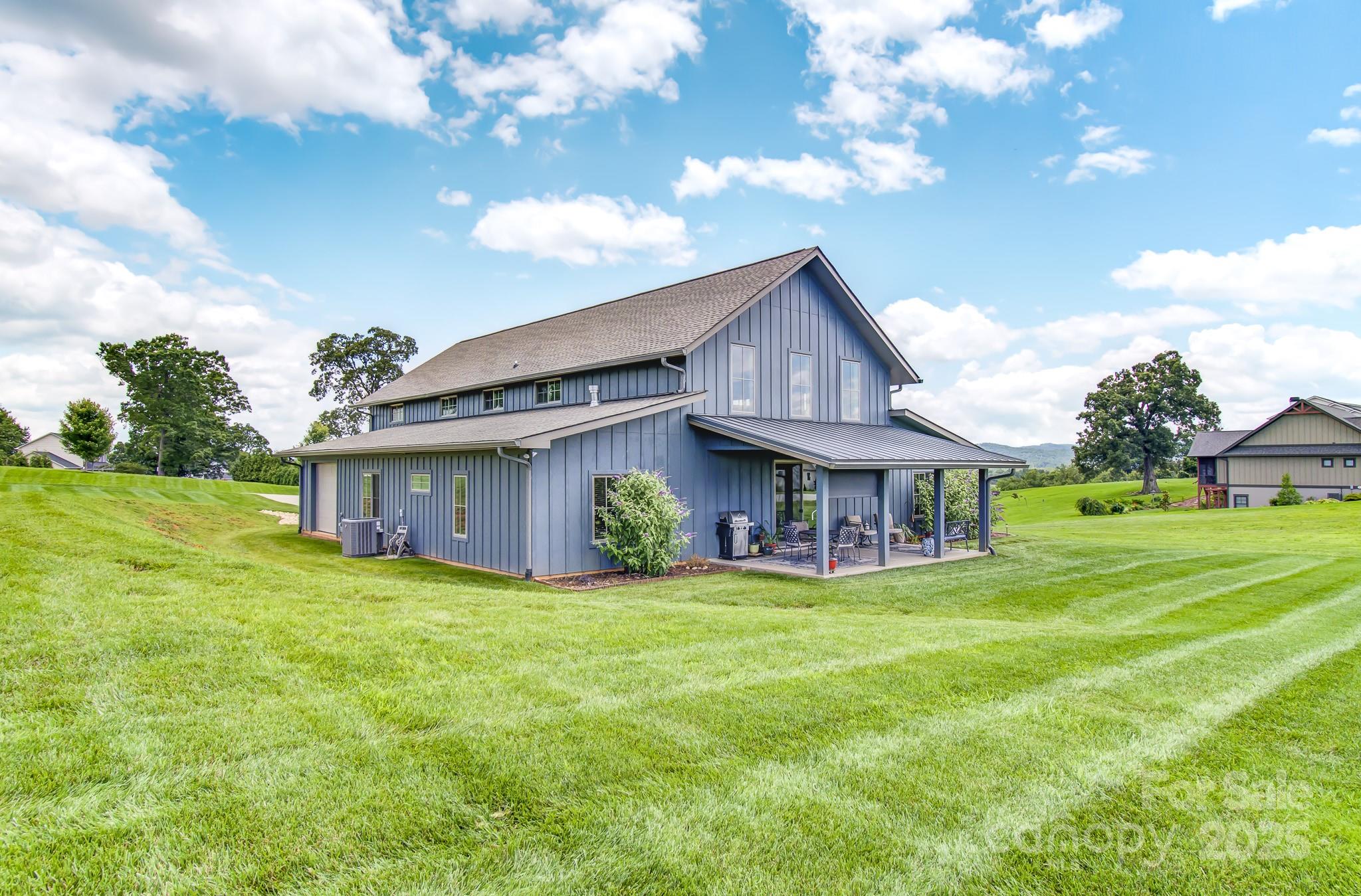 a view of a house with a big yard and large trees