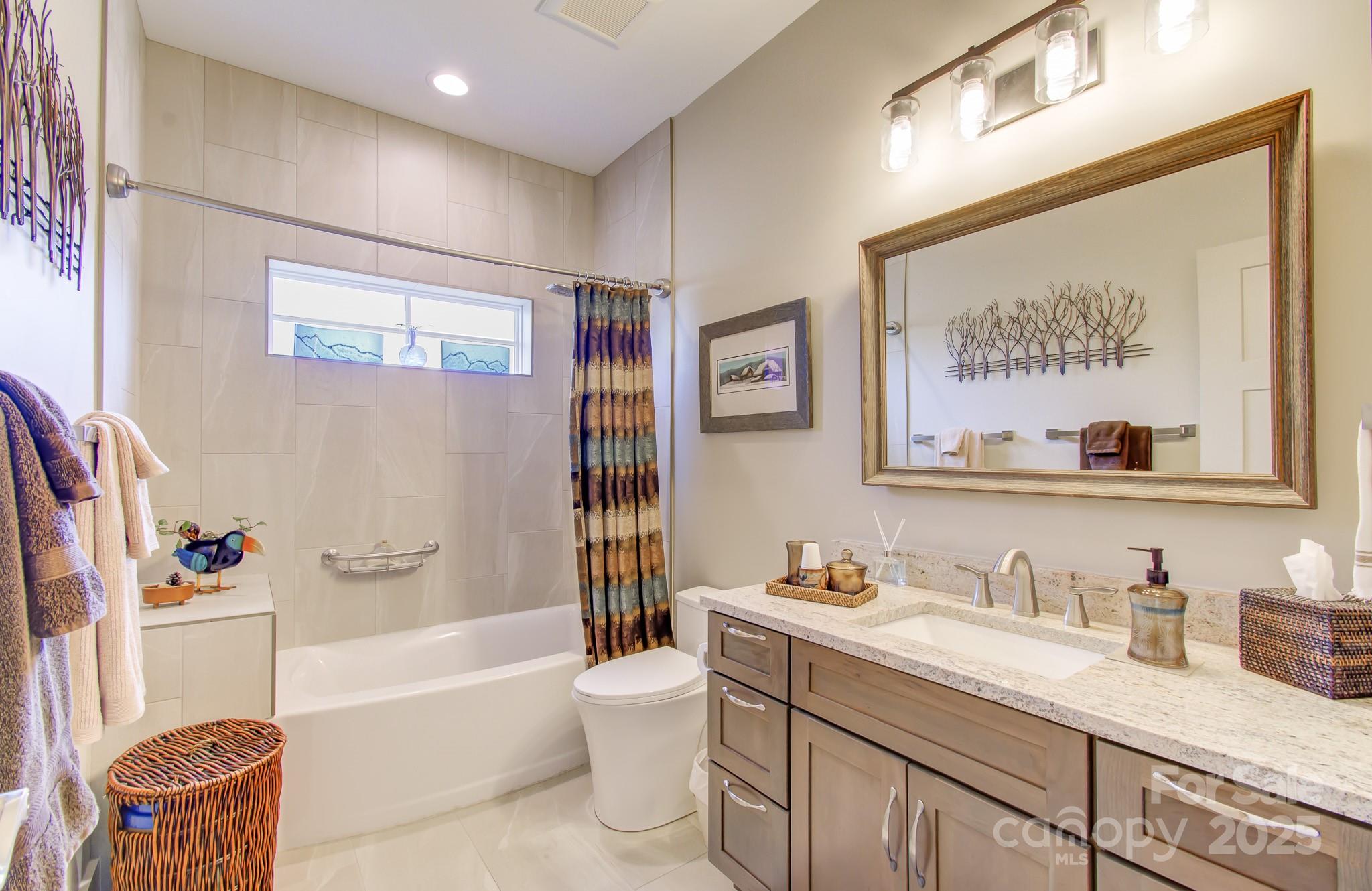 147 Majestic Ridge Road Mills River, NC 28759 - Photo 30 of 48 a bathroom with a granite countertop sink mirror toilet and bathtub
