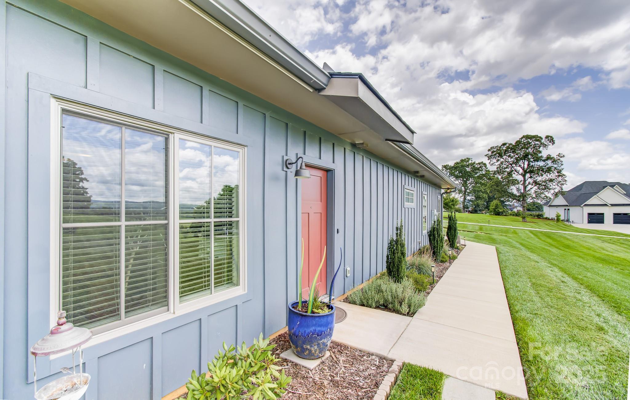 147 Majestic Ridge Road Mills River, NC 28759 - Photo 4 of 48 a front view of a house with a yard and potted plants
