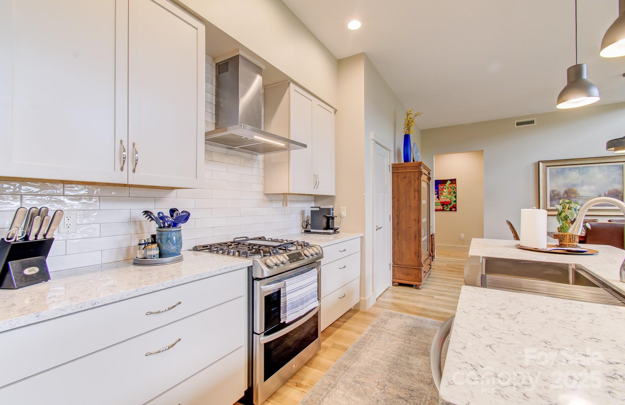 147 Majestic Ridge Road Mills River, NC 28759 - Photo 8 of 48 a kitchen with stainless steel appliances granite countertop a stove a sink and a white cabinets