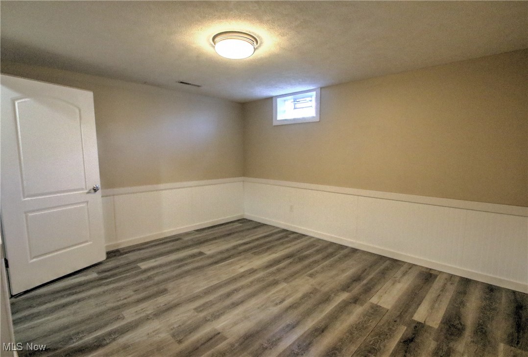 4998 Wayne Road Mantua, OH 44255 - Photo 26 of 43 basement bonus room featuring wood-type flooring and a textured ceiling