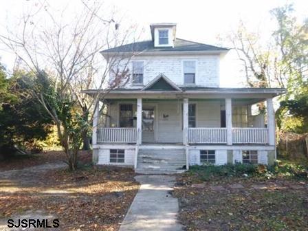 1708 Shore Road Northfield, NJ 08225 - Photo 1 of 1 a view of a brick house with large windows and a yard