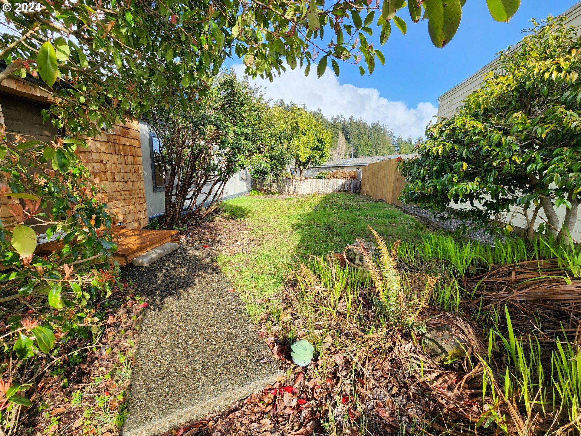 100 River Bend Road, Unit 127 Reedsport, OR 97467 - Photo 15 of 21 a view of a yard with plants and large trees