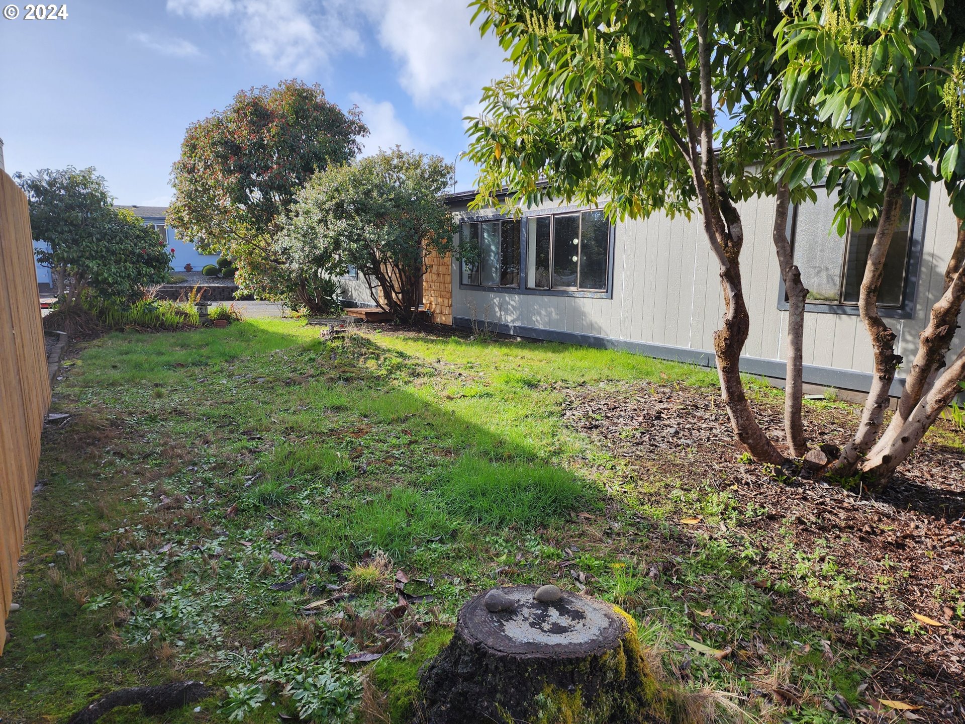 100 River Bend Road, Unit 127 Reedsport, OR 97467 - Photo 17 of 21 a view of a backyard with plants and a tree